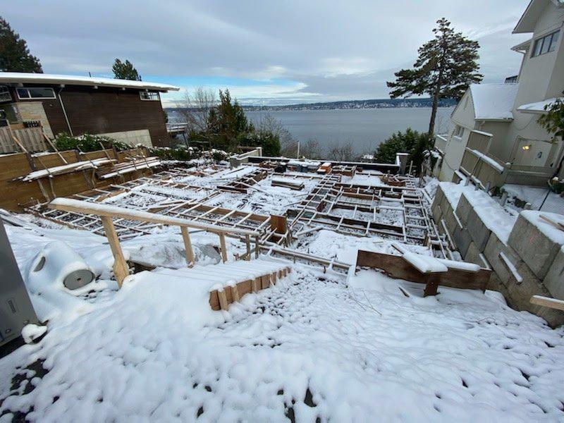 Waterfront custom foundation forms on a snowy hillside site — HTS Concrete & Construction