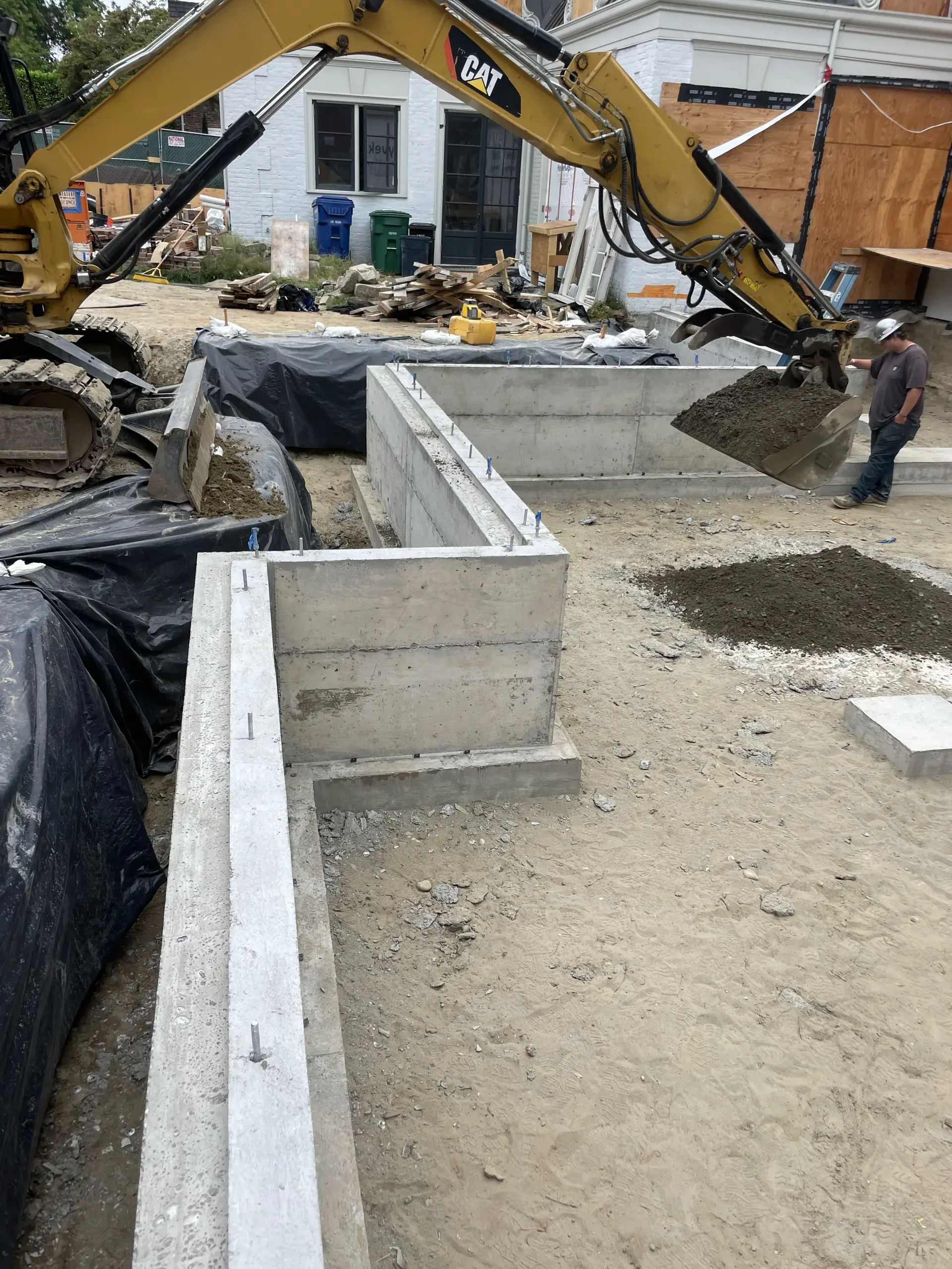 Mini excavator working beside foundation forms