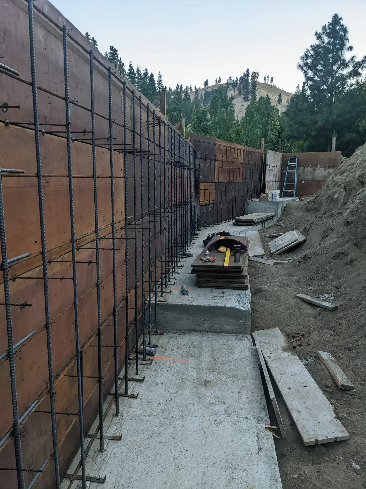 Excavated dirt bank prepared for a retaining wall footing