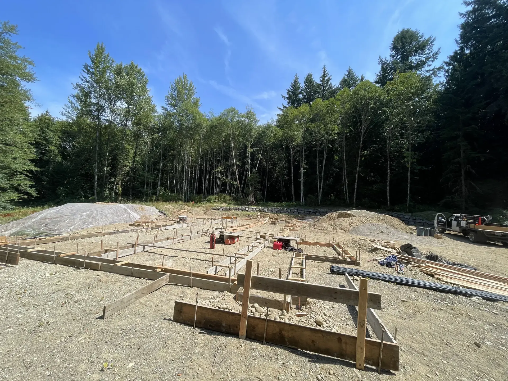 Cleared wooded lot with a foundation pad and formwork