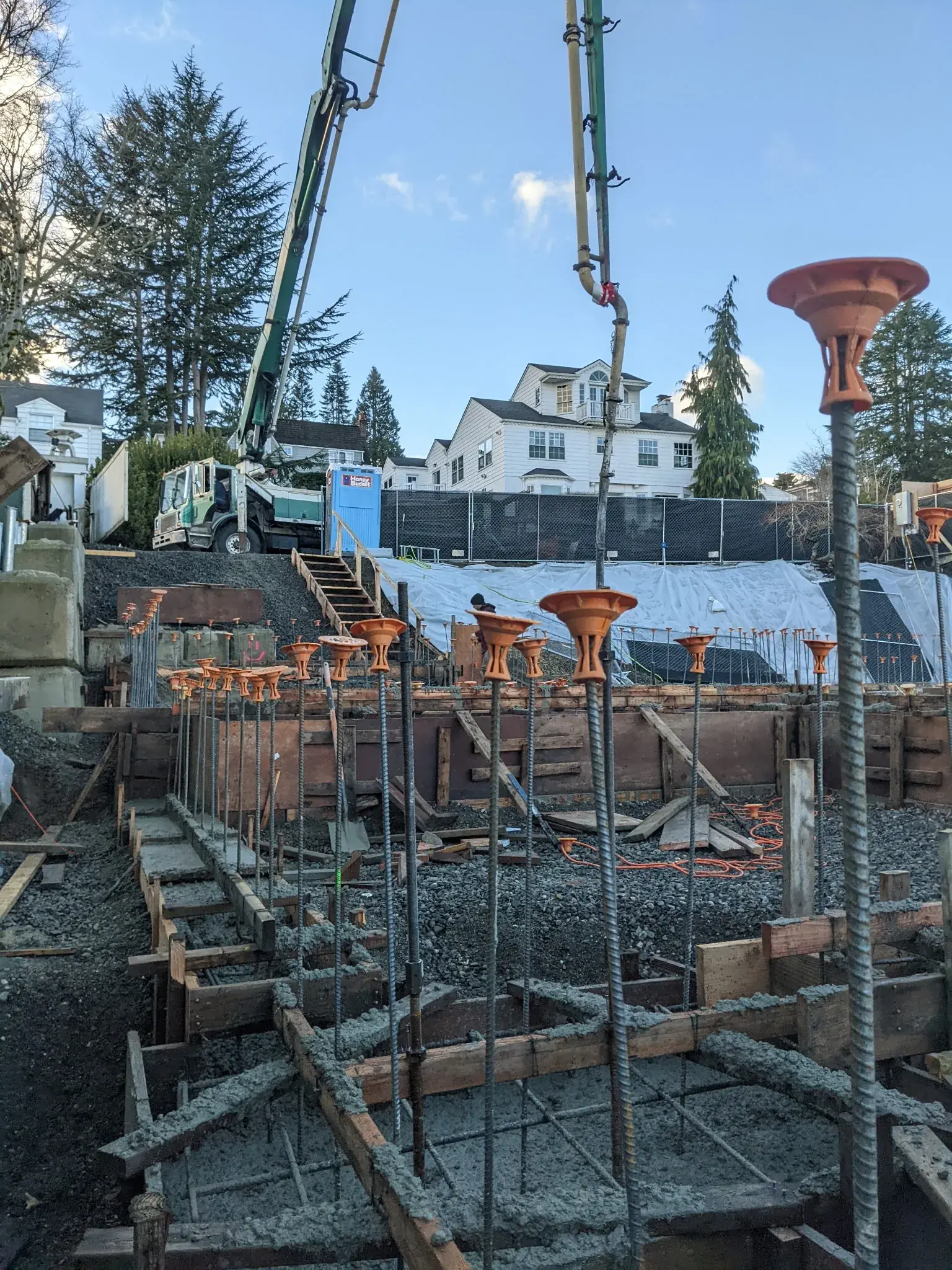 Foundation forms and rebar with concrete pump on site — HTS Concrete & Construction