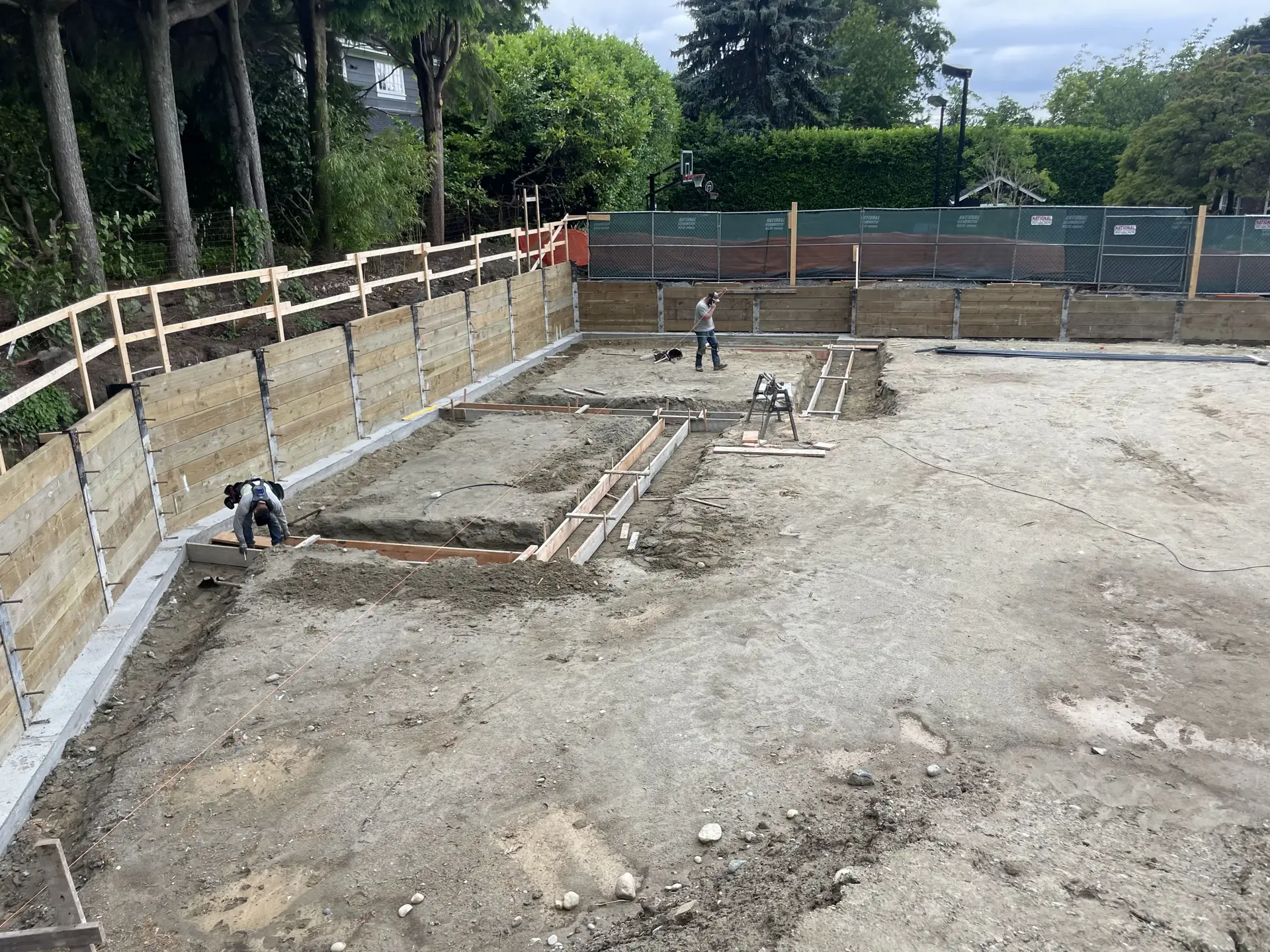 Excavated residential site with foundation forms in progress — HTS Concrete & Construction