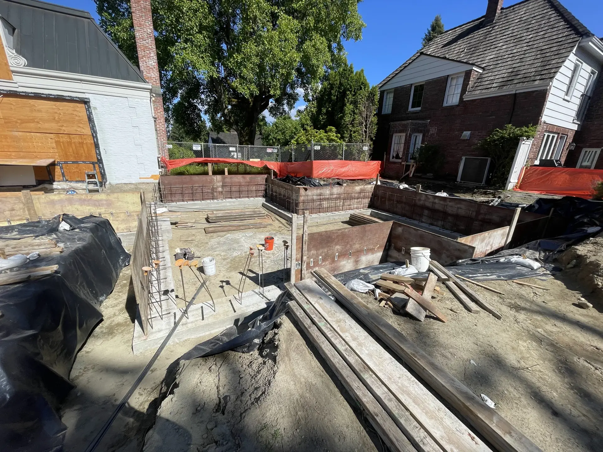 Large excavation site with dirt banks and safety fencing