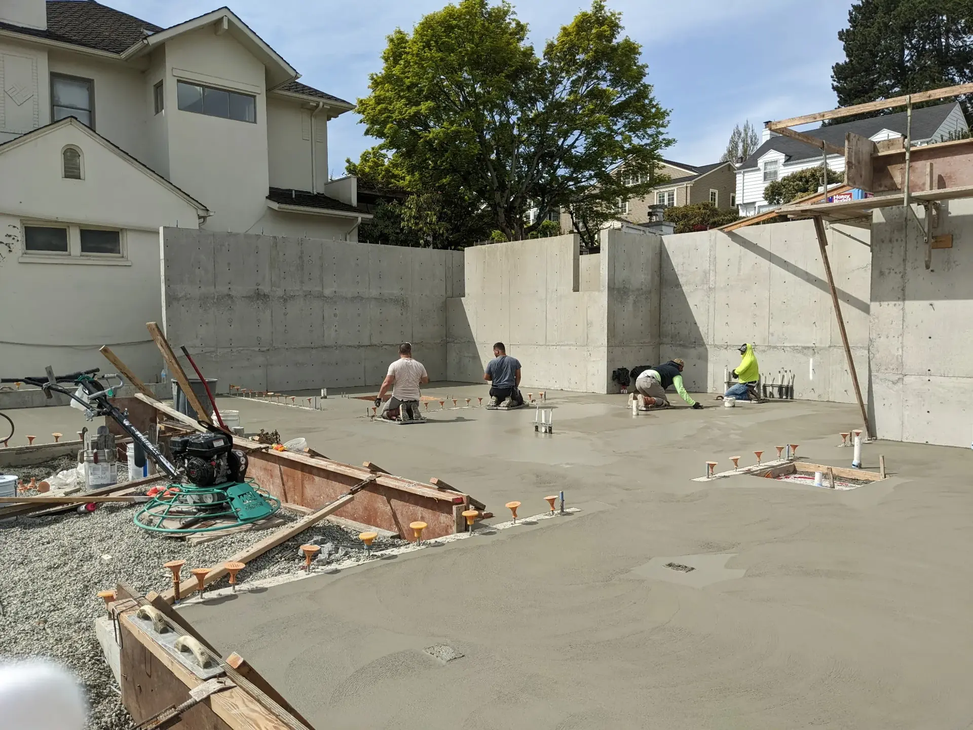 Crew finishing a residential slab foundation pour — HTS Concrete & Construction