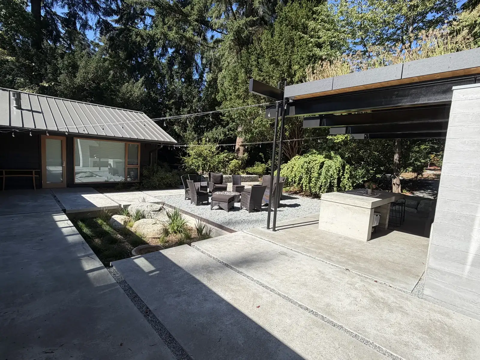 Architectural concrete outdoor living with board-formed walls, patio slabs, and custom outdoor kitchen