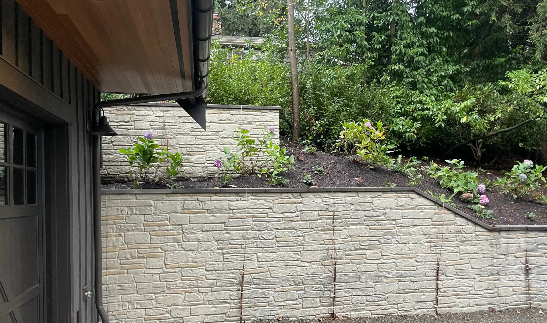 Stone-form concrete retaining wall with garden planting